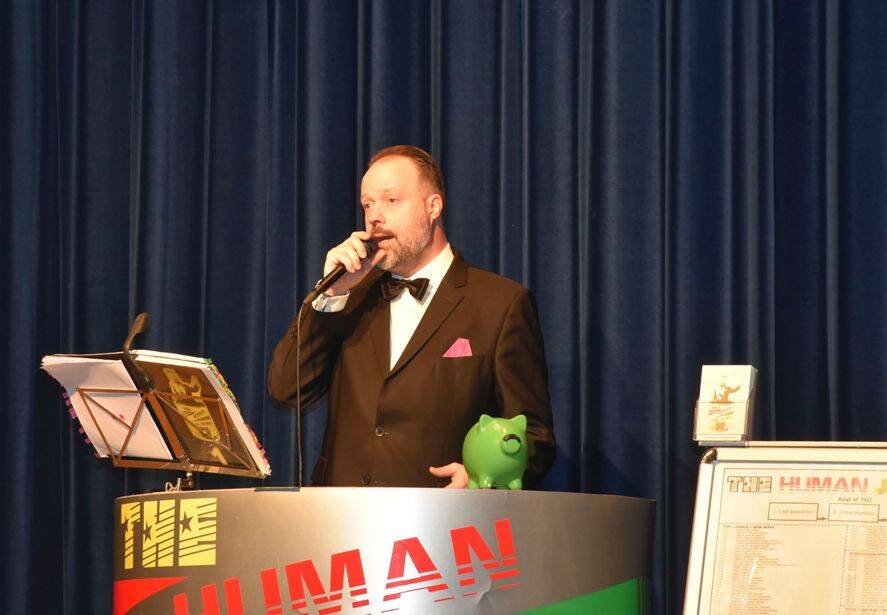 Michael Wäckerlin singt mit dem Mikrophon aus seiner Juke-Box, die aussieht wie eine Kanzel vor unserem dunkelblauen Bühnenvorhang ein Lied